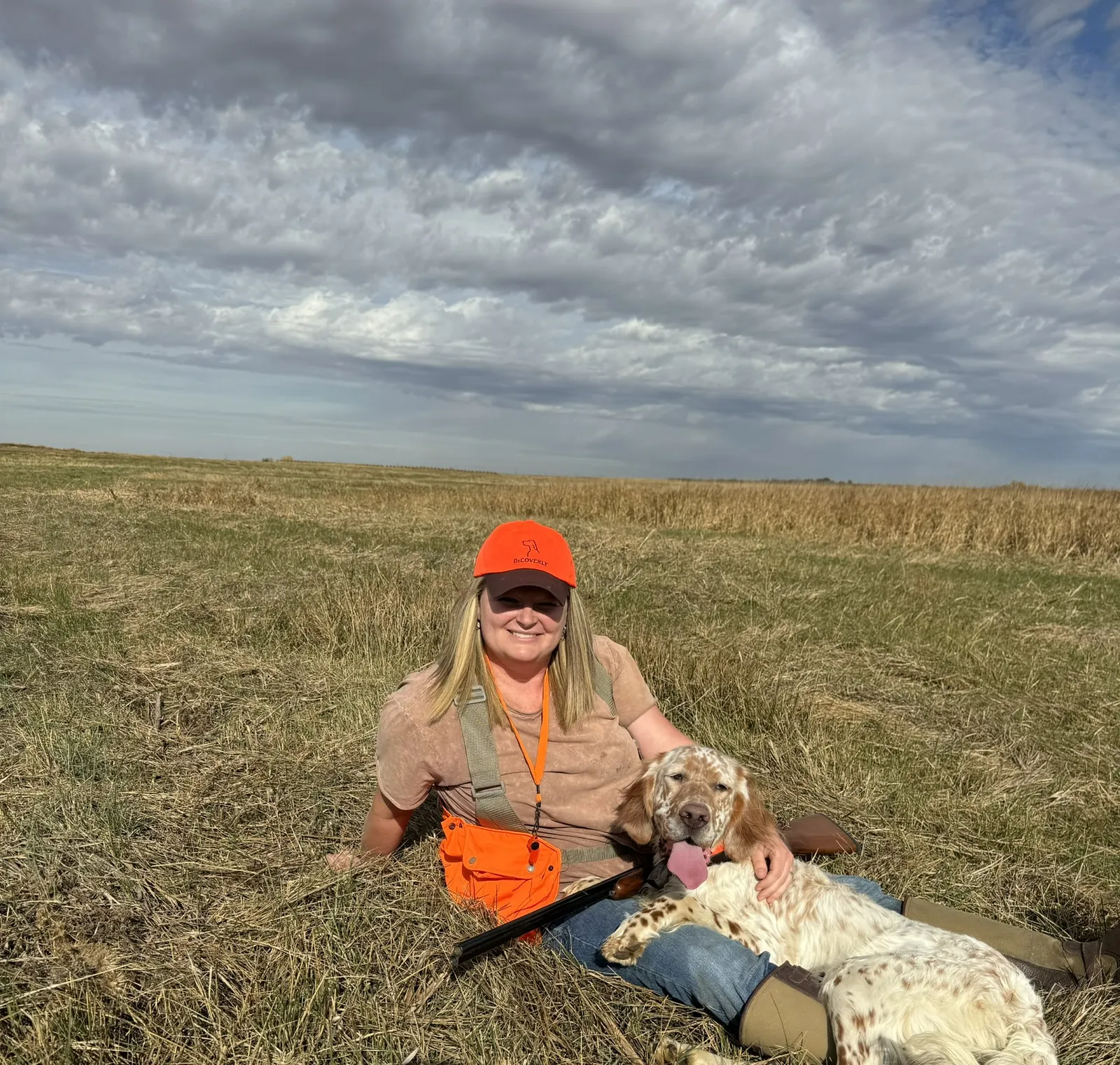 Courtney sitting in the field with Buster